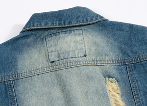 Detailed close-up of denim vest collar with distressed ripped holes and yellow stitching