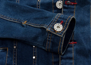 Detail of dark blue denim jacket featuring yellow contrast stitching and metal buttons