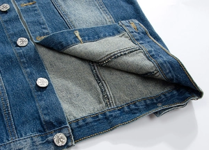 Macro shot of dark blue denim hem featuring vintage silver embossed metal buttons