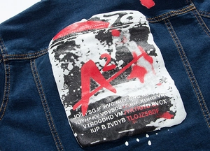 Close-up of slim fit denim jacket back featuring white graphic prints and orange stitching