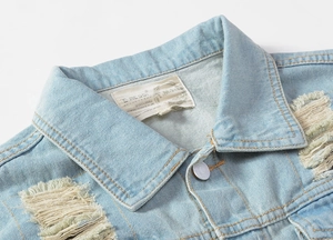 Close-up of the light blue denim vest collar with distressed details and woven brand label