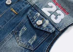Detail of blue denim vest with white number 23 patch and eagle crest metal button