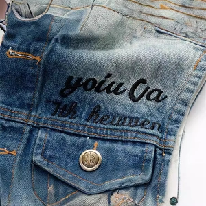 Close-up of slim fit denim vest with 7th heaven embroidery and vintage button details