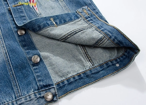 Detailed close-up of blue denim vest with metal jeans buttons and embroidered logo