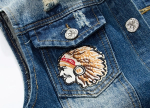 Detail of vintage blue denim vest with Indian feather embroidery and metallic buttons