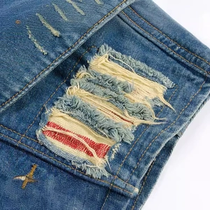 Slim fit dark blue denim vest with ripped distressed details and golden embroidery