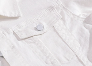 Close-up of white stretch denim jacket showing pocket detail and textured stitching