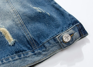 Close-up of blue denim vest featuring vintage eagle embossed metal buttons and distressed details