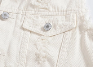 Detailed close-up of white distressed denim vest with raw edges and silver metal buttons