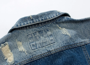 Detail of distressed collar and vintage washed denim texture on men's blue vest