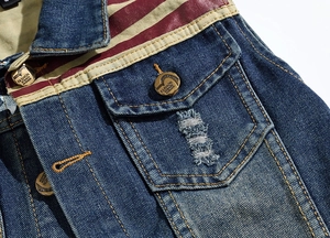 Detail of blue denim vest featuring red and white striped shoulder patchwork and vintage buttons