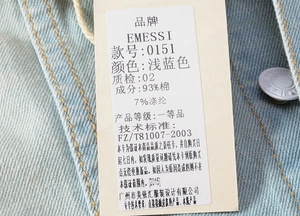 Detail of light blue denim vest tag with cotton blend material info and brand labeling