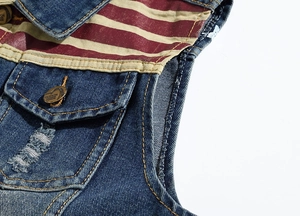 Detail of slim fit denim vest showing USA flag pattern patchwork and metal fashion button