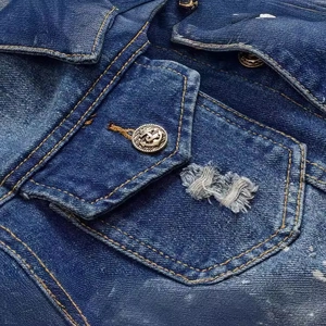 Distressed dark blue denim jacket featuring anchor metal button and paint splatter details