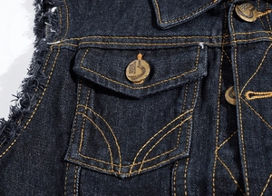 Detail of blue denim vest showing contrast orange stitching and frayed edges