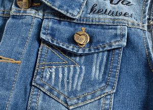Detail of blue denim vest featuring flap pocket, vintage metal buttons and embroidery