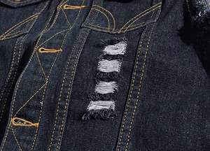 Detailed close-up of heavy dark blue denim vest featuring distressed ripped hole effects