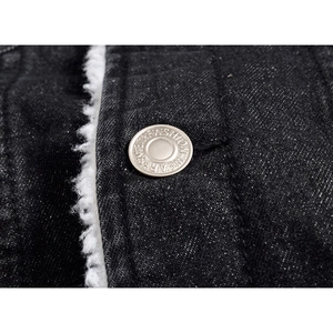 Detailed close-up of a men's black denim jacket with white fleece lining and metal button