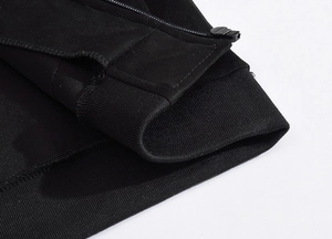Close-up of black men's vest showing ribbed knit hem and premium metallic zipper detail