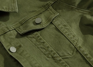 Detail of army green denim jacket showing chest flap pocket and metal jeans buttons