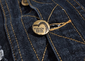 Macro detail of retro copper button with fashion text on premium denim fabric