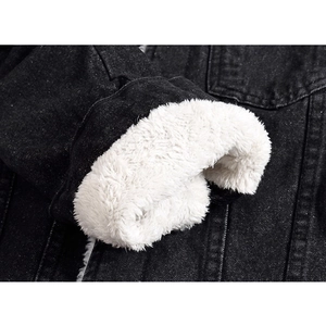 Detail of black denim jacket featuring warm white faux lamb wool lining on sleeve cuff