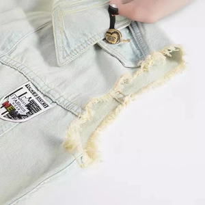 Slim fit light blue denim vest with frayed edges and retro fashion patches