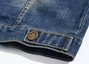 Detail shot of denim vest hem with vintage gold button and washed twill texture