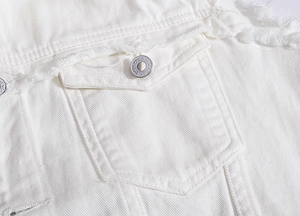 Detail der weißen Jeansweste mit ausgefransten Taschenkanten und Premium-Metallknopf