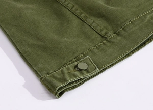 Detailed close-up of army green twill jacket fabric with JEANS engraved button