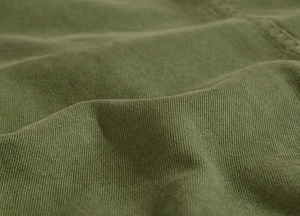 Detailed close-up showing the fine cotton twill texture and stitching of the army green jacket