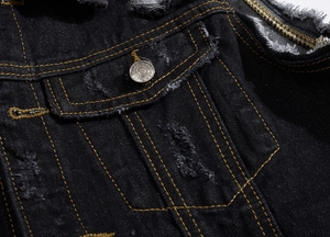 Detail of distressed black denim vest with contrast yellow stitching and metal buttons