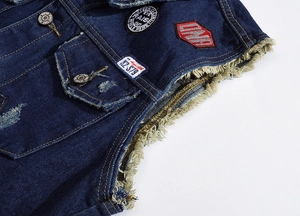 Detail of dark blue denim vest featuring metal buttons and vintage style patches