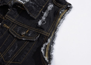 Detail of black denim vest featuring contrasting yellow stitching and distressed edges