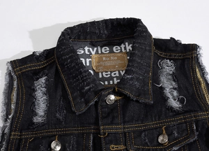 Close-up of distressed denim vest featuring ripped details and a premium leather neck label