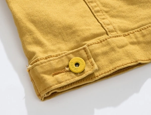 Close-up of yellow denim jacket showing high-quality stitching and metal JEANS button
