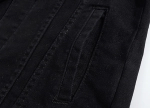 Detail of grey denim jacket showing double-stitched seams and slanted pocket texture