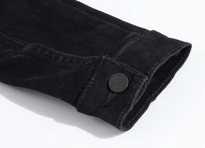 Detailed macro view of gray washed denim jacket cuff with a branded metal button