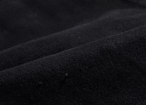 Macro shot of grey stretch denim fabric texture and washed finish on men's jacket