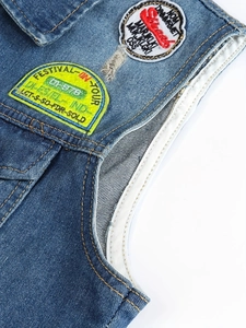 Dettaglio del gilet in denim blu con ricami vintage e cuciture gialle a contrasto
