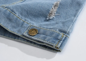 Close-up of light blue denim vest showing ripped detail and fashion metal button