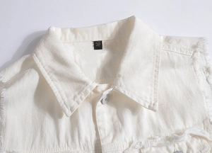 Detailansicht der weißen Jeansweste mit ausgefransten Kanten und Denim-Textur