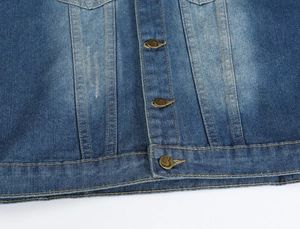 Dettaglio del gilet di jeans con bottoni in rame a cuore e cuciture gialle a contrasto