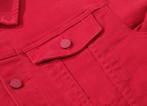 Detail view of the red denim jacket showing the chest pocket and metal jeans button