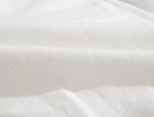Macro scatto del tessuto in twill di cotone bianco con trama dettagliata della giacca