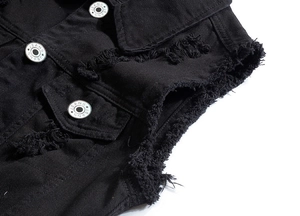 Détail de la veste sans manches en jean noir avec bords effilochés et boutons métalliques
