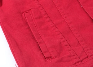 Detail of red denim jacket featuring high-quality double-row stitching and flat pocket