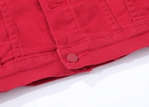 Macro shot of red denim jacket fabric texture and painted metal button detail