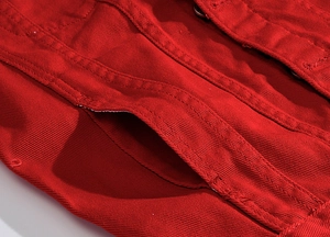 Macro detail of red utility jacket featuring reinforced double stitching and side pocket design