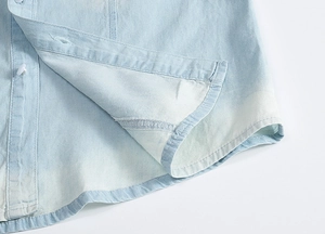 Detailed view of light blue denim vest with white button and neat stitching quality